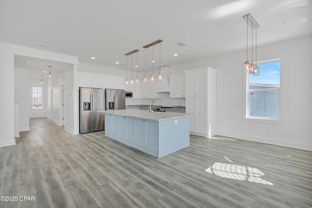 kitchen featuring light wood-type flooring, a sink, white cabinets, stainless steel fridge with ice dispenser, and high end refrigerator