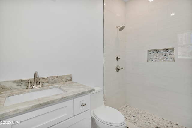 full bath with vanity, toilet, and tiled shower