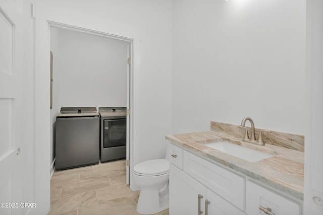 bathroom with independent washer and dryer, toilet, and vanity