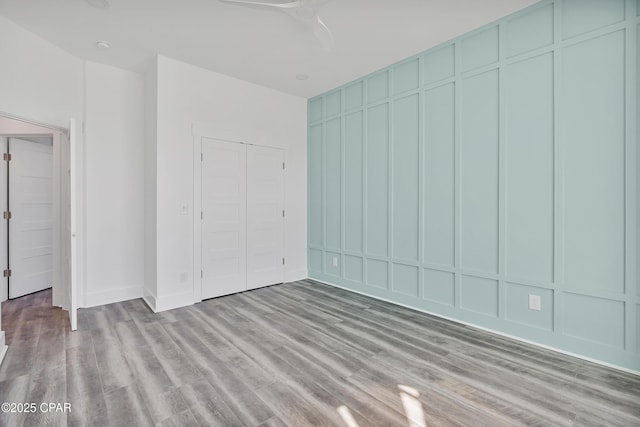 unfurnished bedroom featuring light wood-type flooring and a decorative wall