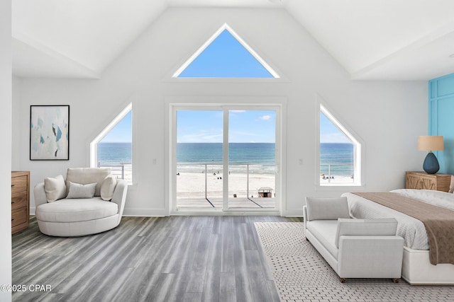 bedroom with access to exterior, baseboards, a water view, wood finished floors, and high vaulted ceiling