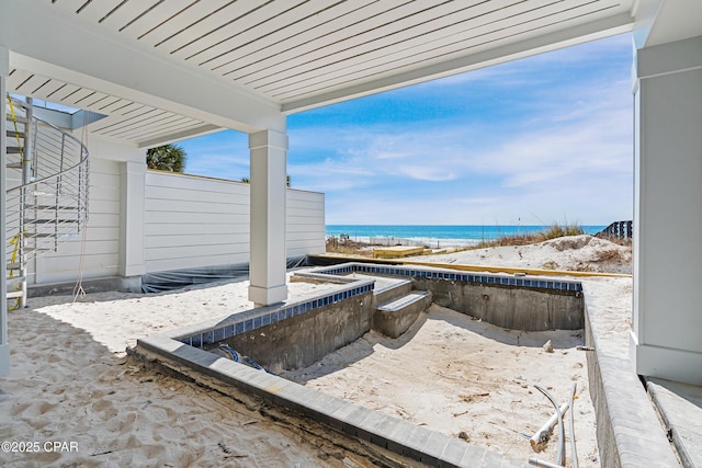 view of patio / terrace featuring a view of the beach and a water view