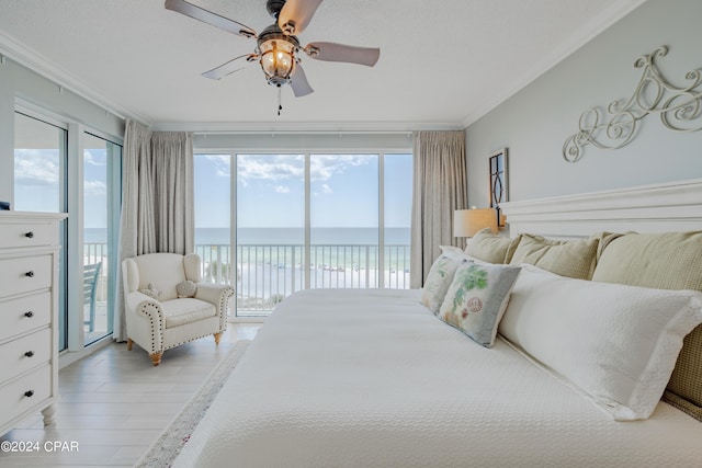 bedroom with a water view, access to outside, multiple windows, and crown molding