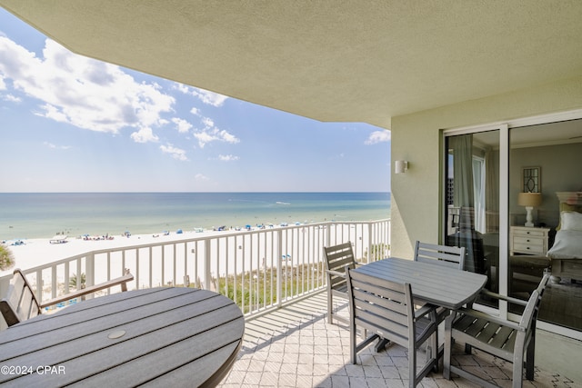 balcony with a water view and a beach view