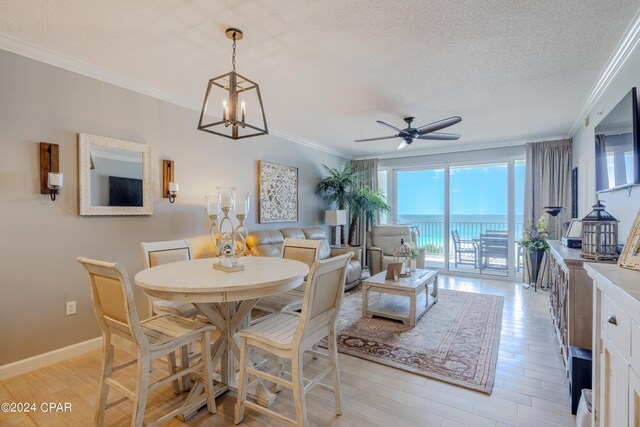 dining space with a textured ceiling, ceiling fan with notable chandelier, crown molding, and light hardwood / wood-style flooring