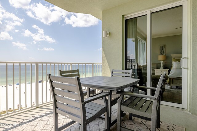 balcony featuring a view of the beach and a water view