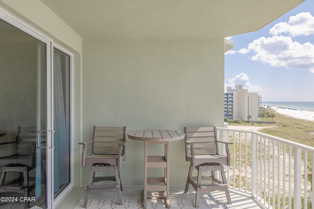 balcony featuring a water view and a beach view