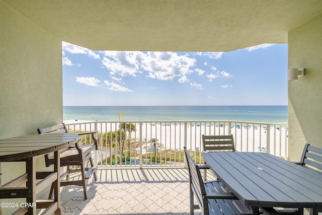 balcony featuring a water view and a beach view