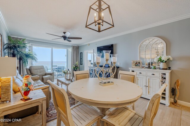 dining space featuring a textured ceiling, ceiling fan with notable chandelier, ornamental molding, and light hardwood / wood-style flooring