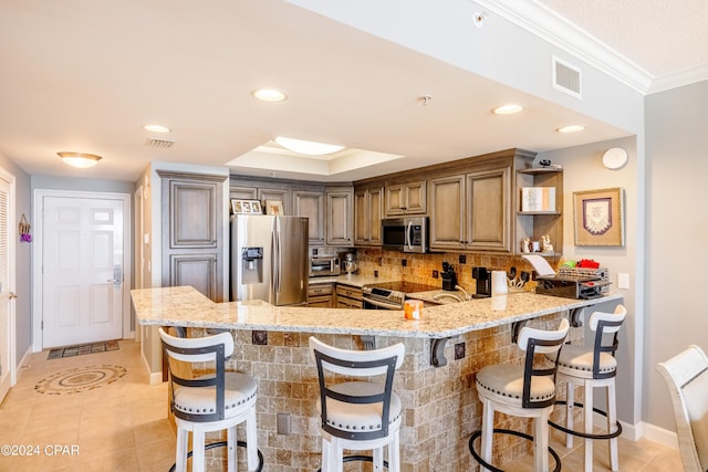 9450 S Thomas Dr Unit 402, Panama City, FL 32408 - kitchen featuring stainless steel appliances, open shelves, a peninsula, light stone counters, and backsplash