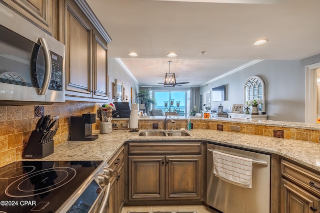 kitchen with light stone countertops, crown molding, stainless steel appliances, and a sink