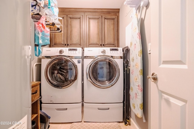 laundry room featuring washing machine and dryer, cabinet space, and light tile patterned floors