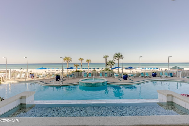 view of swimming pool with a water view and a patio