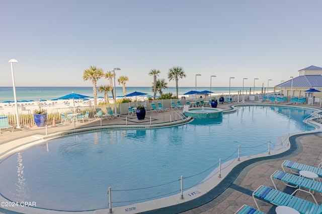 view of pool with a patio, a water view, and fence