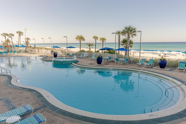 view of pool featuring a patio, a water view, and a community hot tub