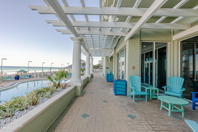 view of patio featuring a water view and a beach view