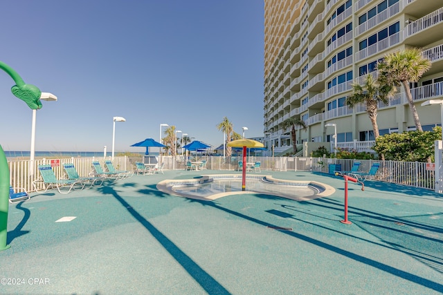 surrounding community with a water view and fence