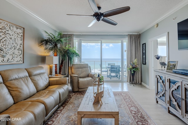 living room with a textured ceiling, ornamental molding, ceiling fan, and light hardwood / wood-style flooring