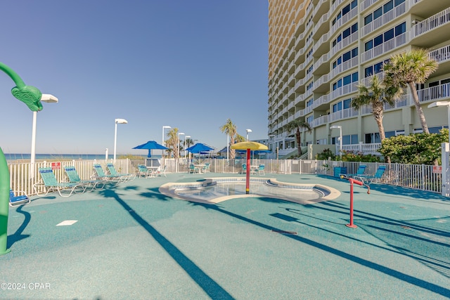 view of community with a patio, a pool, and a water view