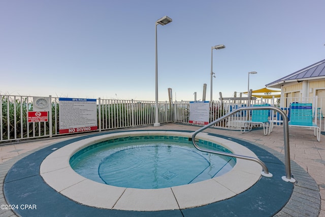 view of pool with fence and a community hot tub