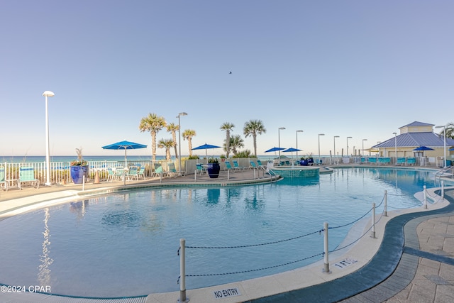 view of swimming pool featuring a water view and a patio area