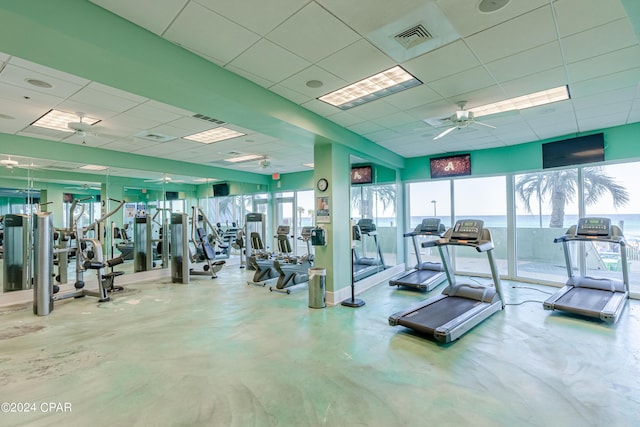 workout area with a drop ceiling, visible vents, and a ceiling fan