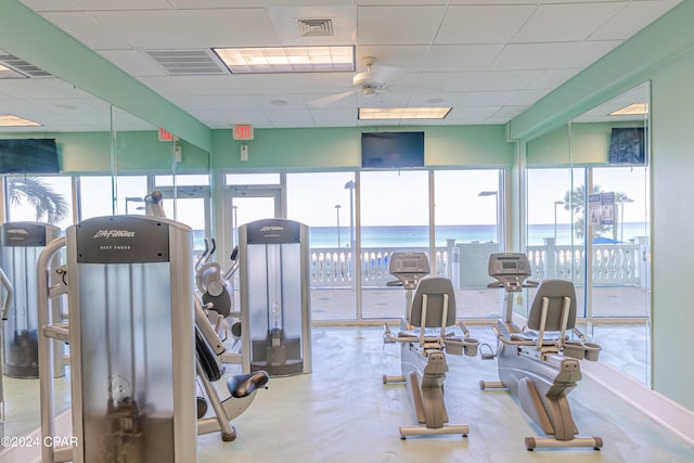 workout area featuring concrete floors, a drop ceiling, and ceiling fan