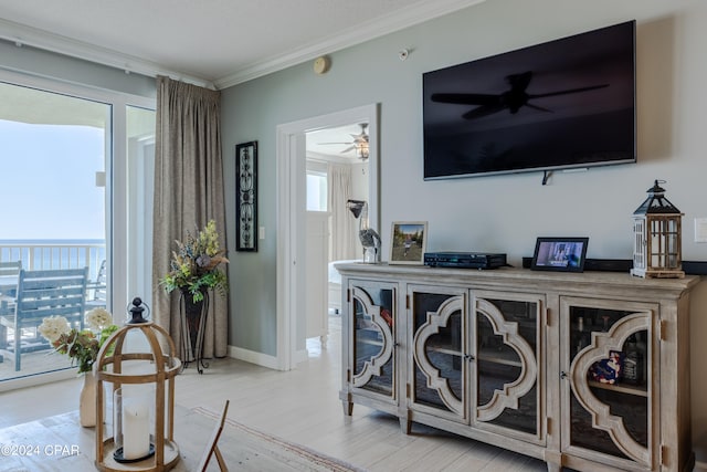 interior space featuring a healthy amount of sunlight, crown molding, wood-type flooring, and ceiling fan