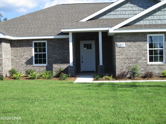 doorway to property with a lawn