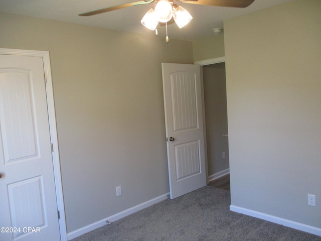 unfurnished bedroom featuring dark carpet and ceiling fan