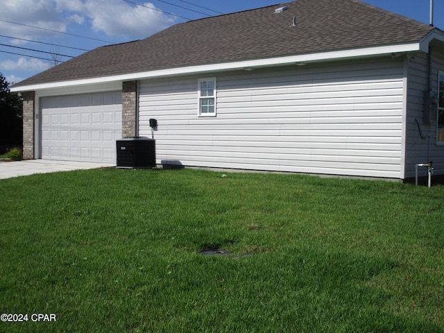 view of side of property featuring a lawn and central AC