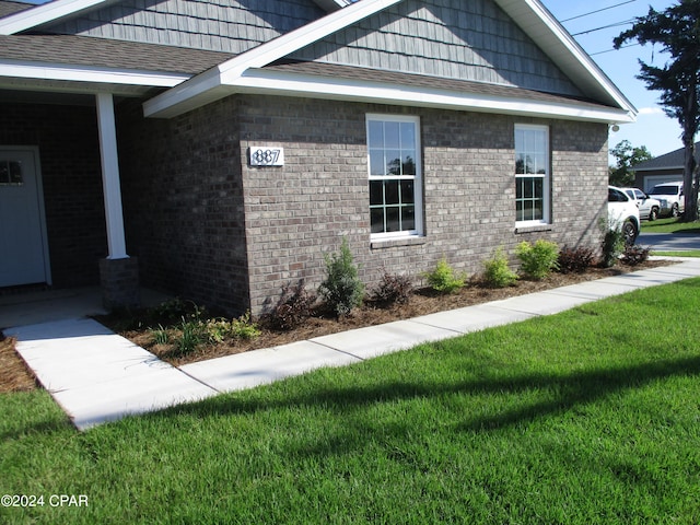 view of side of home with a yard