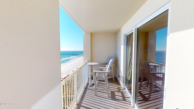 balcony featuring a water view and a view of the beach