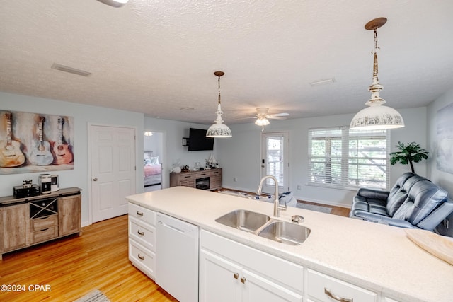 kitchen featuring decorative light fixtures, white dishwasher, light hardwood / wood-style flooring, and sink