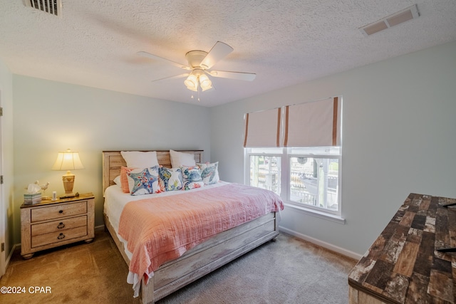 carpeted bedroom with ceiling fan and a textured ceiling