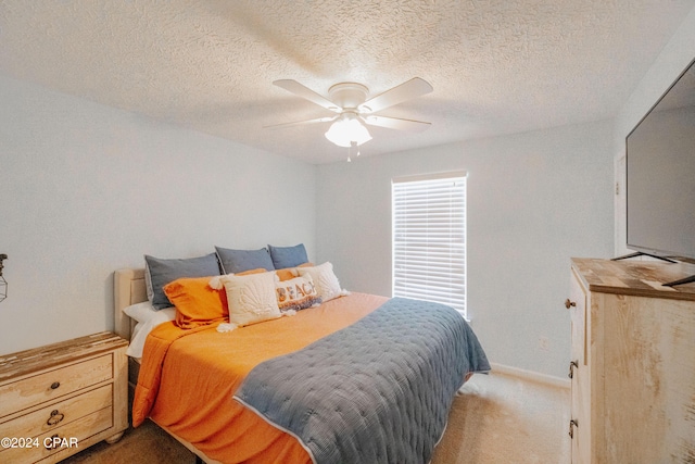 carpeted bedroom with ceiling fan and a textured ceiling