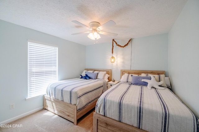 carpeted bedroom featuring ceiling fan, a textured ceiling, and multiple windows