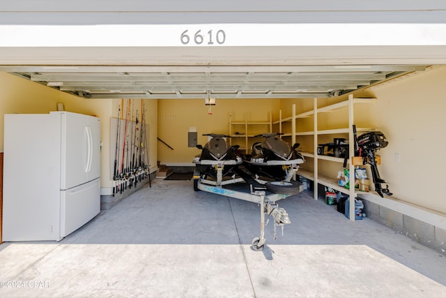 garage featuring white refrigerator and electric panel