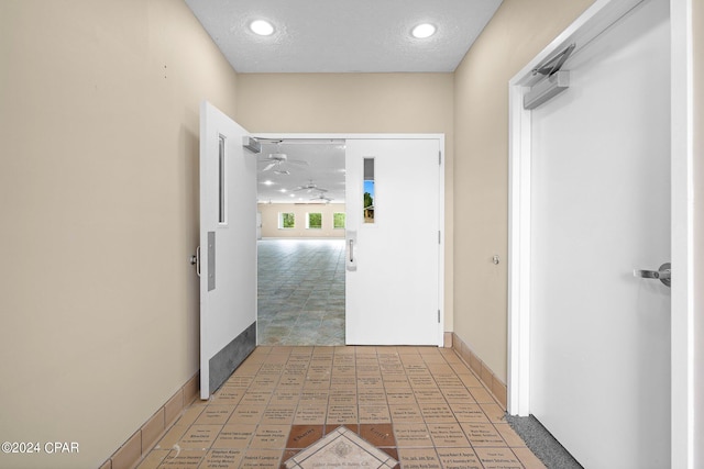 corridor featuring a textured ceiling and carpet floors