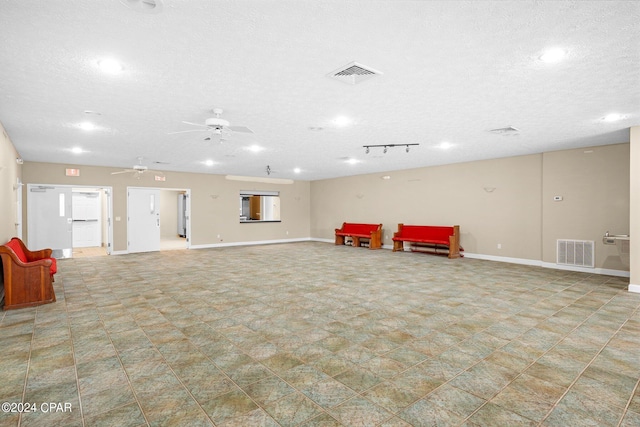 interior space featuring ceiling fan and a textured ceiling