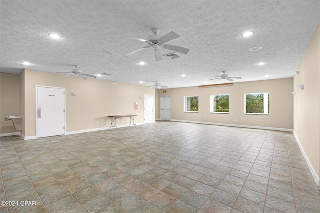 unfurnished room with ceiling fan and a textured ceiling