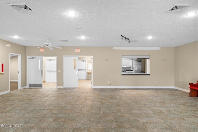 unfurnished room featuring ceiling fan and a textured ceiling