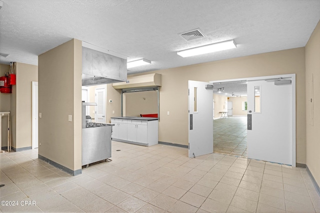 kitchen with white cabinets and a textured ceiling