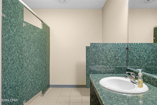 bathroom with tile patterned flooring, a textured ceiling, and vanity