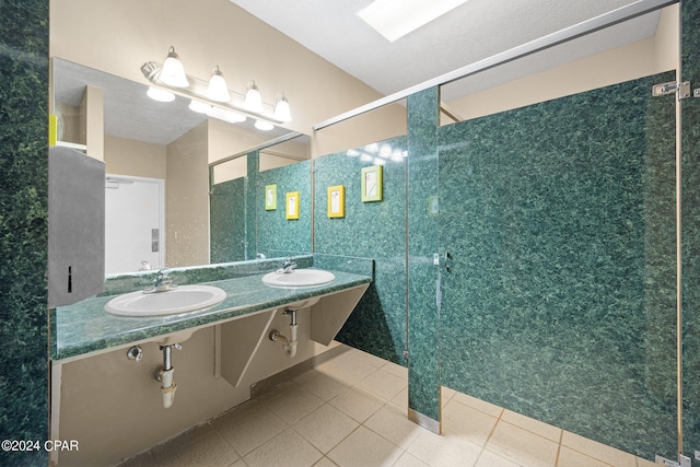 bathroom with walk in shower, a skylight, vanity, and tile patterned floors