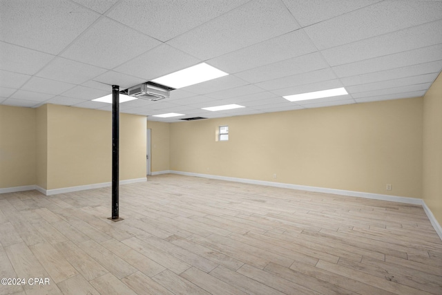 basement with a drop ceiling and light wood-type flooring