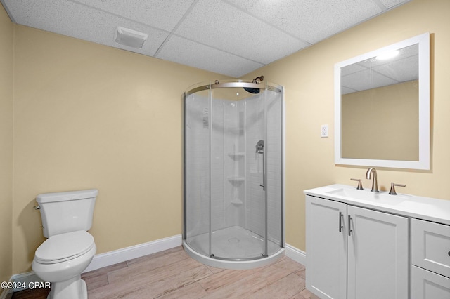 bathroom featuring hardwood / wood-style flooring, walk in shower, vanity, and toilet