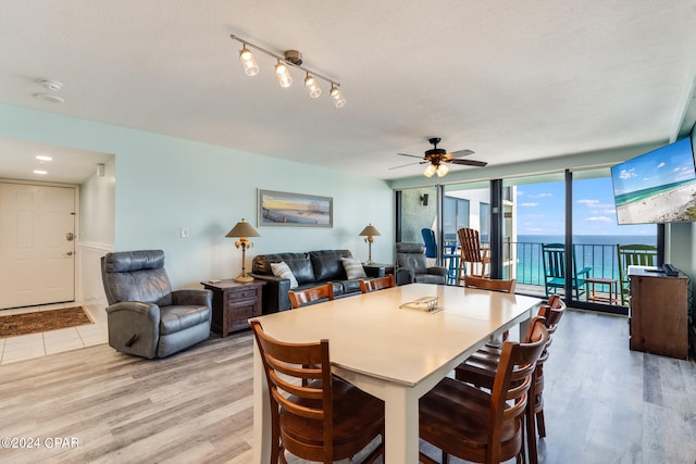 dining area featuring ceiling fan, a textured ceiling, and light wood-type flooring