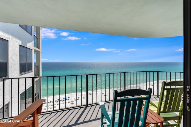 balcony featuring a water view and a beach view