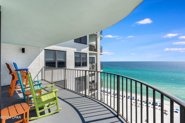 balcony featuring a water view and a view of the beach